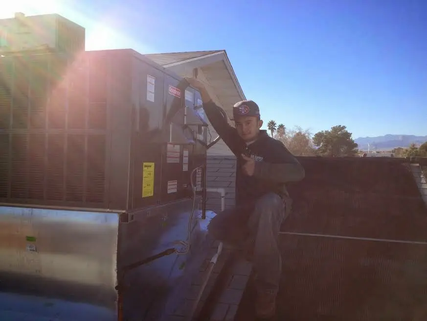 HVAC technician performing Air Duct Repair on a rooftop unit in Hernando